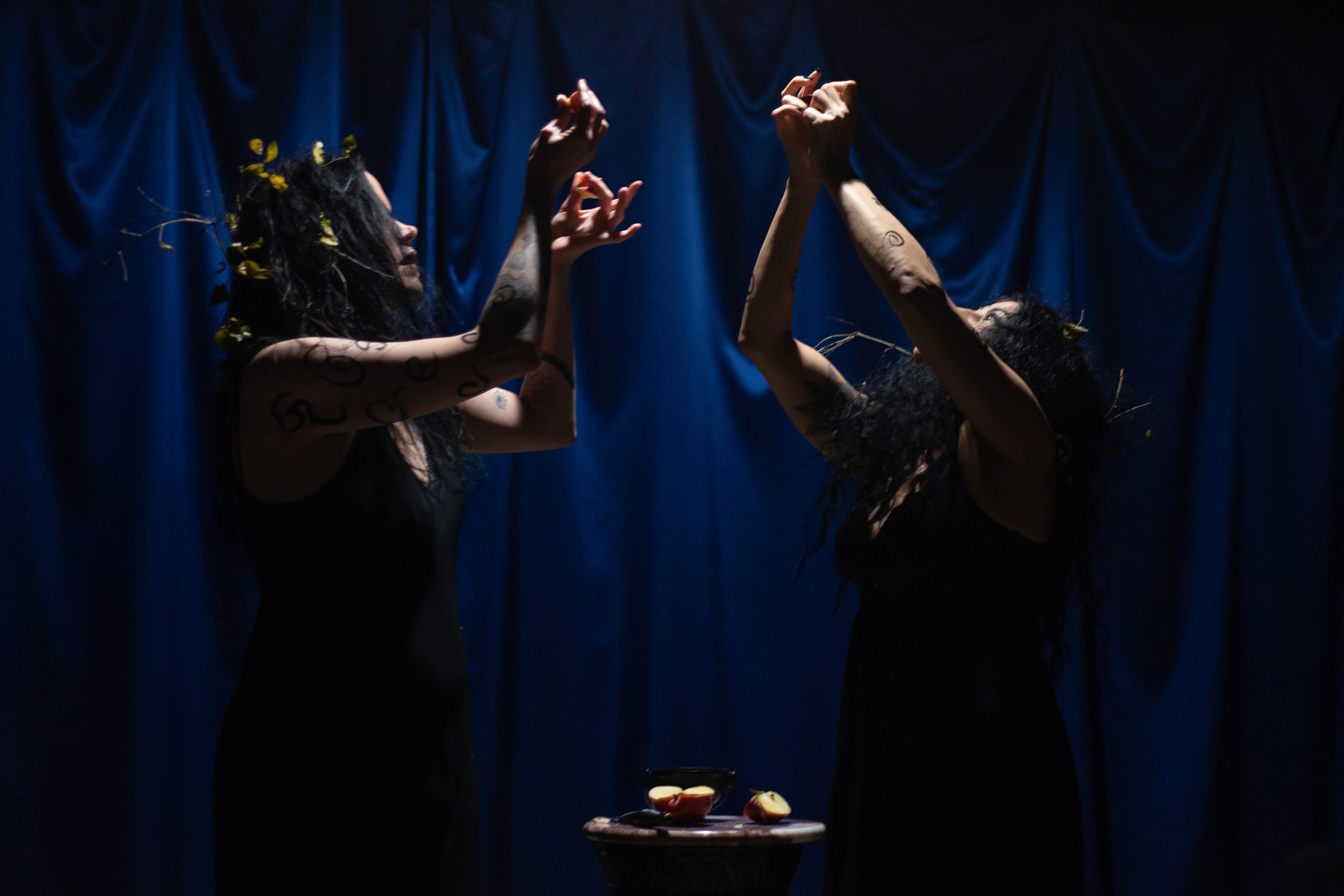 two women holding the cut up apple pieces aloft